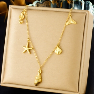 Detail view of gold chain necklace featuring seahorse, starfish and shell ocean charms