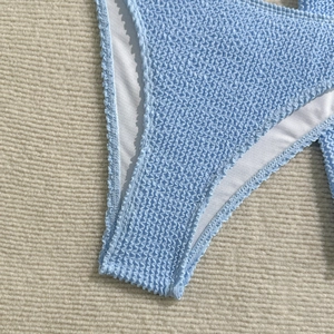 Detail of light blue bikini bottom with wavy seersucker texture and white lining fabric