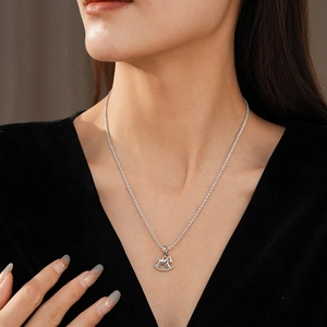 Dettaglio della collana con ciondolo cavallo a dondolo argento e pietre micro-pavé lucide