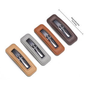 Detail of four PU leather hair clips with stitching and metal snap mechanism in various tones