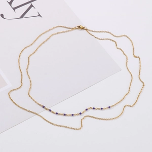 Vue macro détaillée d'un collier doré double épaisseur avec perles violettes et chaîne O