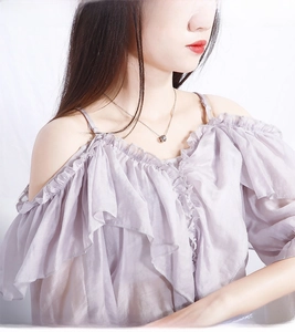 Close-up of model wearing a silver hollow cylindrical pendant with an O-chain necklace