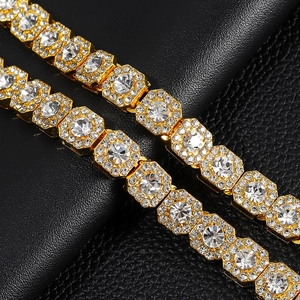 Detail of gold Cuban chain featuring square links with large clear stones and pave accents