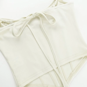 Detailed close-up of cream white corset top showing structural seams and lace-up design