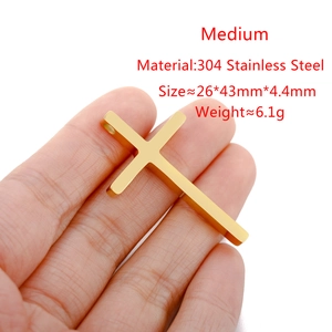 Handheld view of a medium 304 stainless steel gold cross pendant with dimensions