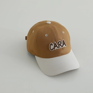 Detail view of contrast stitching and 3D embroidered letters on kids baseball cap