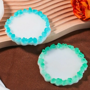 Détail de moules à sous-verres ronds avec bords en cristal bleu et vert en résine