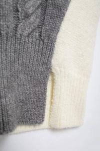 Close-up of gray cable knit and cream ribbed sweater fabric texture details