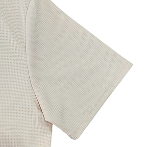 Primer plano de la textura de punto gofrado beige en polo de hombre casual