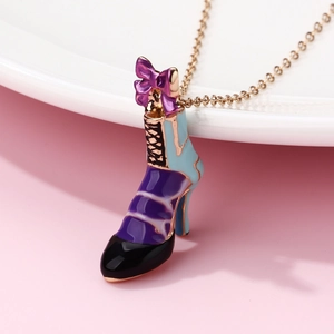 Dettaglio macro del ciondolo a scarpa con tacco in smalto viola e fiocco dorato