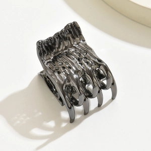 Minimalist black metal hair claw clip with unique skeletal design and hollow dot texture
