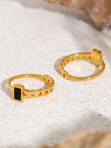 Detailed view of two gold-plated chain rings with black rectangular mother of pearl inlay