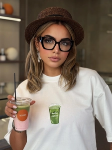 Detail of white cotton T-shirt featuring green matcha cup print and retro street style text