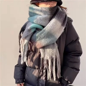 Detail of soft mohair-like texture on plaid scarf with fringe in grey and blue
