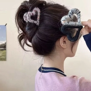 Plush heart-shaped hair claw clips in grey, black, and pink colors for women