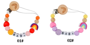 Detail of wooden pacifier clips with silicone beads, crochet balls, and baby lettering