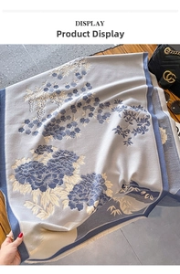 Detail of blue winter scarf with traditional floral embroidery and soft fringe edges