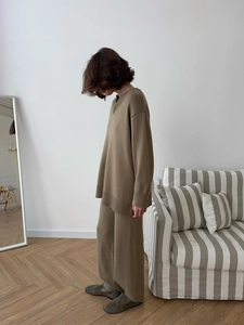 Détail d'un pull en maille ample et d'un pantalon large en tissu marron olive