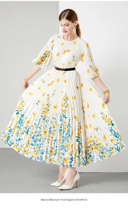 Detail van witte geplooide midi-jurk met levendige gele en blauwe bloemmotieven