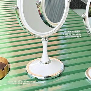 Detail of a round makeup mirror featuring a stable weighted base and imitation metal texture