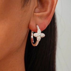 Close-up of zircon flower earring worn on earlobe showing intricate micro-pave craftsmanship