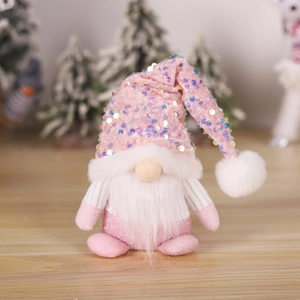 Pink sequined knit Christmas gnome plush doll with long white beard on wooden surface