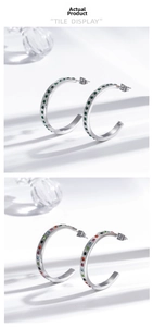 Detail view of C-shaped stainless steel earrings with emerald and rainbow pavé rhinestones