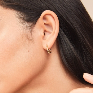 Close-up of model wearing polished 18K gold U-shaped flat geometric earrings