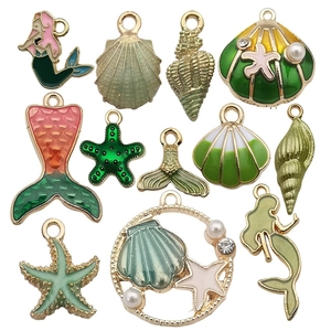 Set of 11 gold-tone enamel ocean charms featuring shells, starfish, and mermaids for DIY crafts