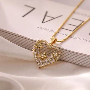 Macro shot of gold heart pendant with zircon star charms on white silk and book