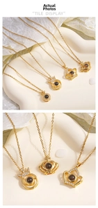 Detail showing gold crown pendants with 100 languages I Love You projection stone