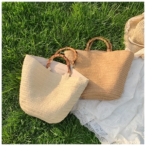 Detailed texture of straw tote bags with vintage bamboo handles on a sunny lawn