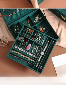 Detailed macro view of green velvet jewelry box featuring multiple divided storage sections