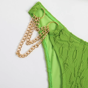 Detail of neon green textured bikini fabric with triple-layered gold metal chain links