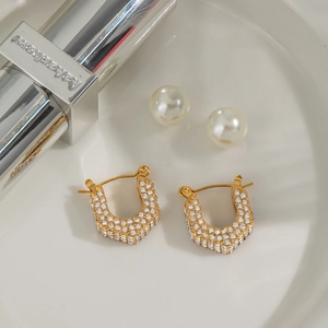 Detail of 18K gold plated U-shaped hexagonal earrings with inlaid sparkling crystals