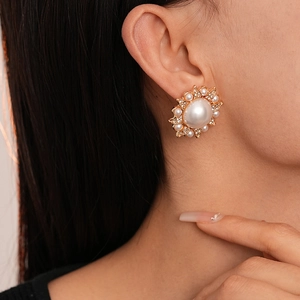 Close-up of vintage baroque pearl flower earrings with rhinestones on a female model