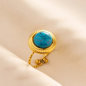 Detailed close-up of a gold adjustable ring with a large round blue turquoise stone
