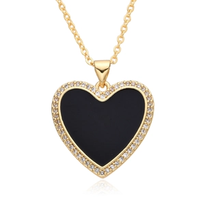 Close-up of gold heart pendant with black enamel center and sparkling zircon stones