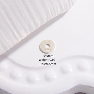 Macro shot of 5mm S925 sterling silver flat disc spacer bead showing the hallmarked stamp