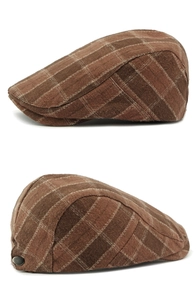 Detail view of brown plaid flat cap featuring thick fabric and retro metal side buckle