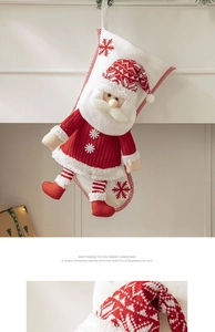 Detail of red knit Christmas stocking with a 3D Santa Claus and snowflake embroidery