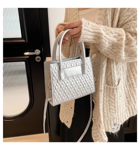 Detail of silver embossed faux leather mini tote bag with stylish top handle and strap