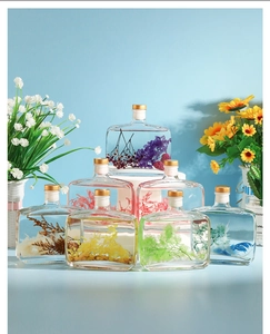 Macro shot of colorful preserved flowers in decorative glass aroma diffuser bottles