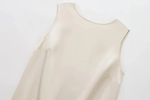 Close-up of elegant beige satin sleeveless top showing smooth silk texture and round neck