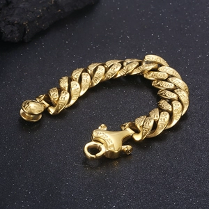 Detailed macro view of gold Egyptian hieroglyphic engravings on a vintage punk curb chain