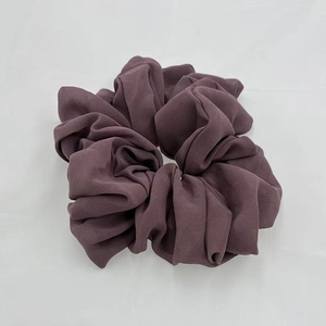 Detail of soft purple chiffon hair scrunchie showing rich pleated fabric texture and elasticity