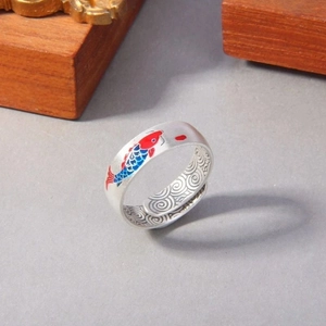 Macro shot of silver koi fish ring with colorful enamel and engraved cloud patterns