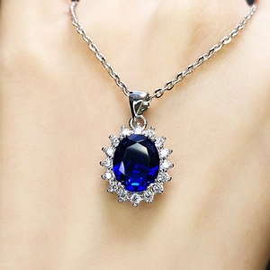 Elegant halo pendant necklace featuring a deep blue oval sapphire and sparkling diamonds