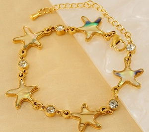 Detail of 18K gold plated starfish bracelet with iridescent shell inlay and zircons