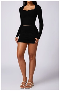 Detail of square neck long sleeve crop top with ruched high waist bodycon skirt in black